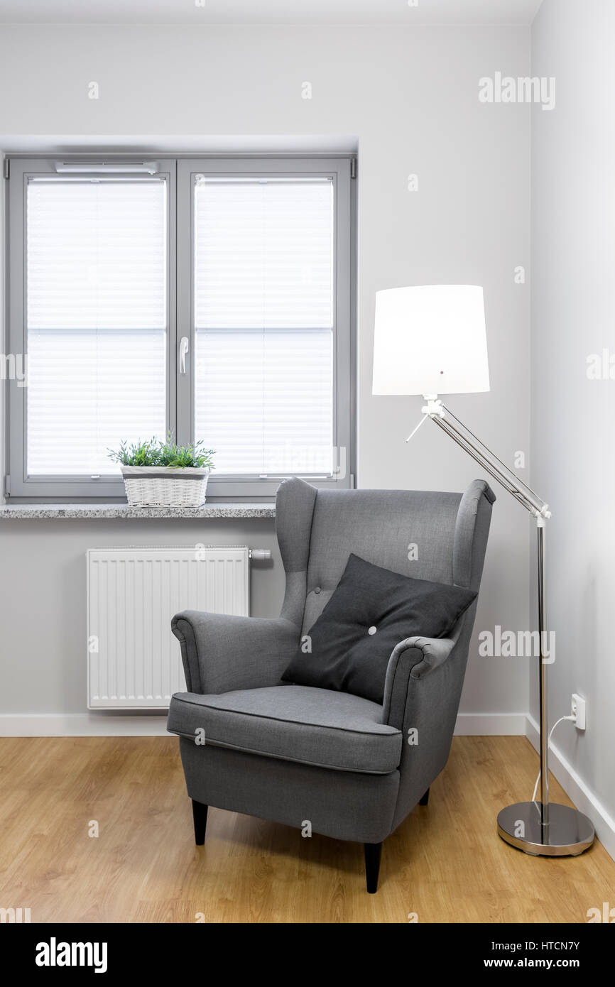 White room with a classy gray armchair and lamp Stock Photo - Alamy