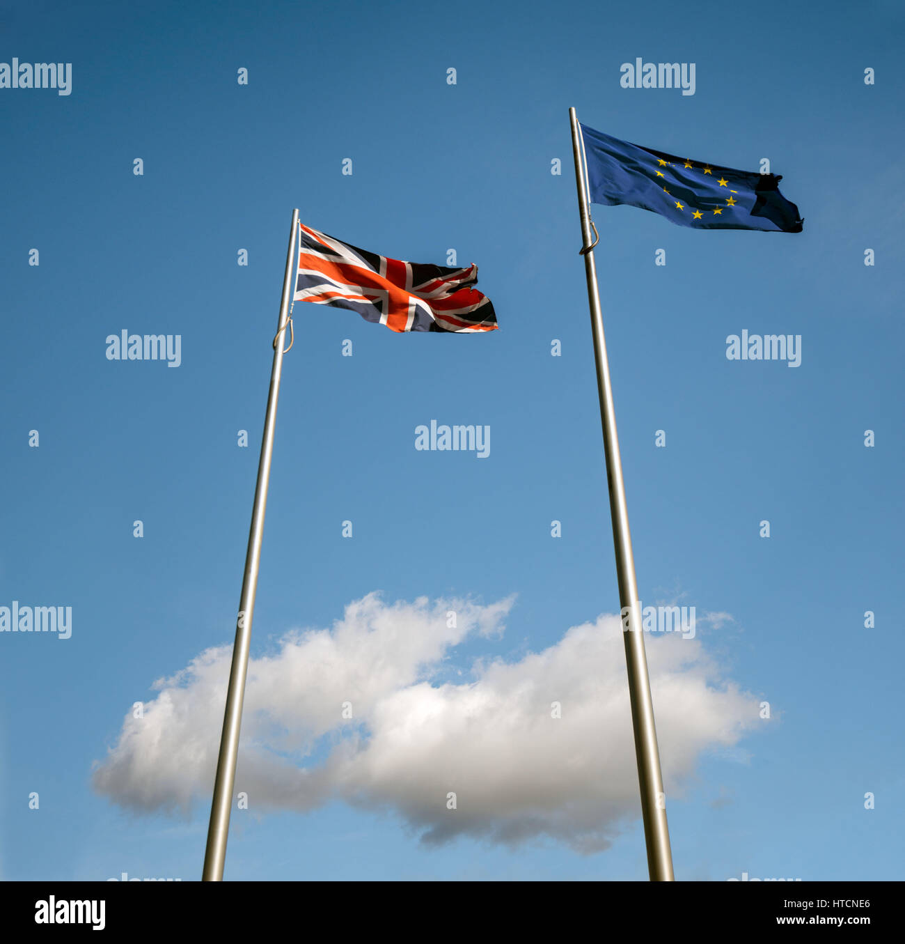 EU flag above UK flags above a single white cloud Stock Photo