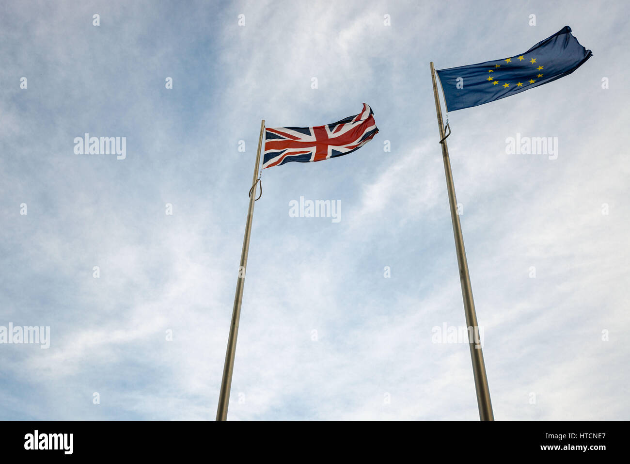 Looking up at EU and UK flags blowing in the wind Stock Photo