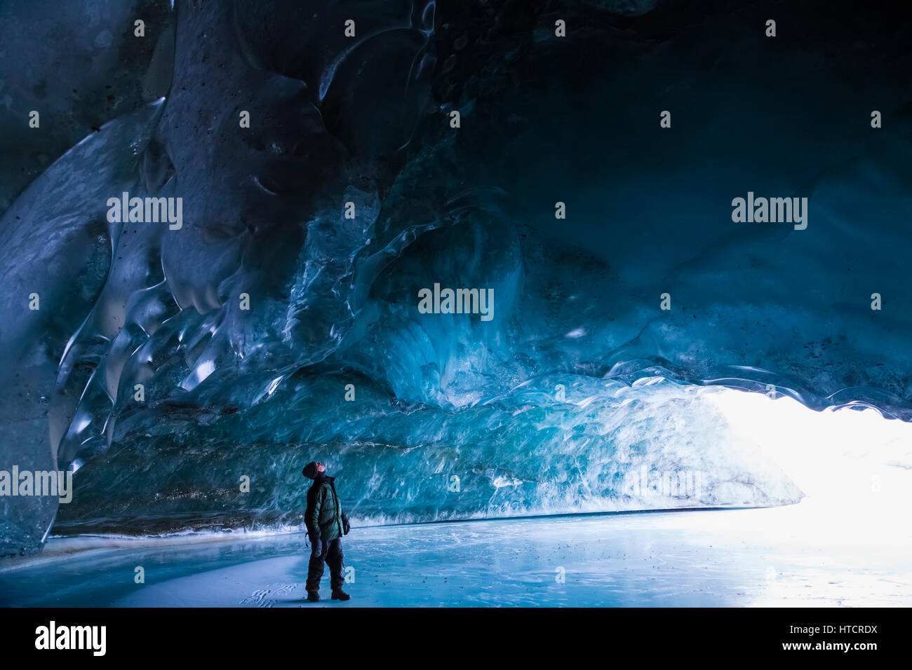 A man studies the ice inside a Canwell Glacier cave on a cold January