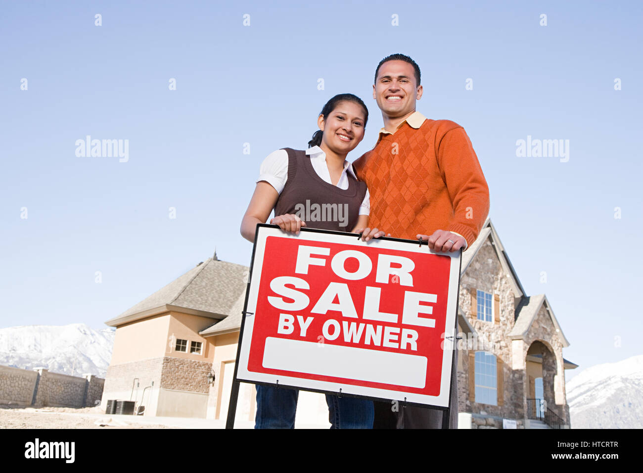Portrait of a couple hold a for sale sign Stock Photo - Alamy