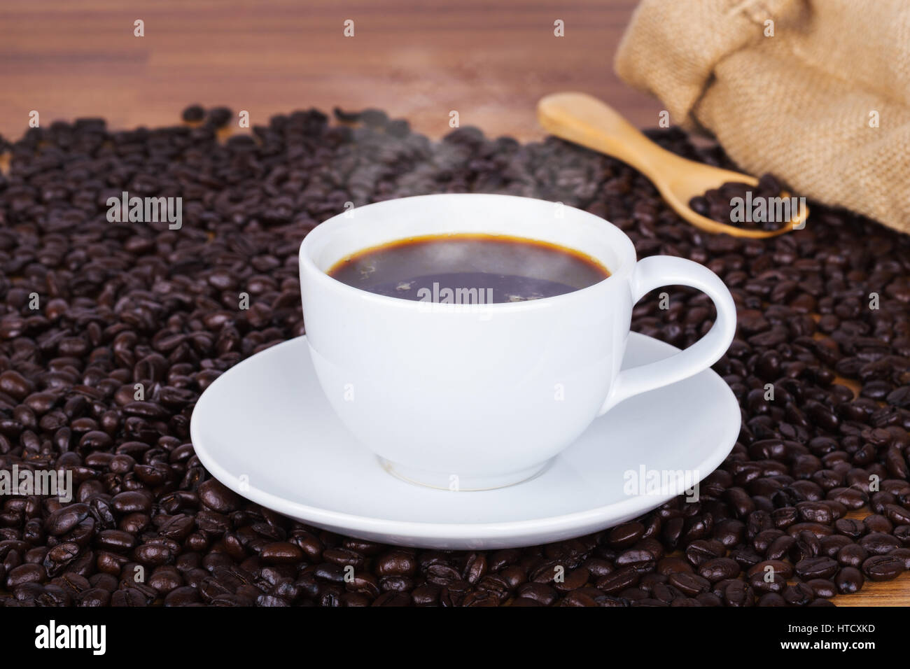 Coffee cup and beans on wooden table background Stock Photo - Alamy