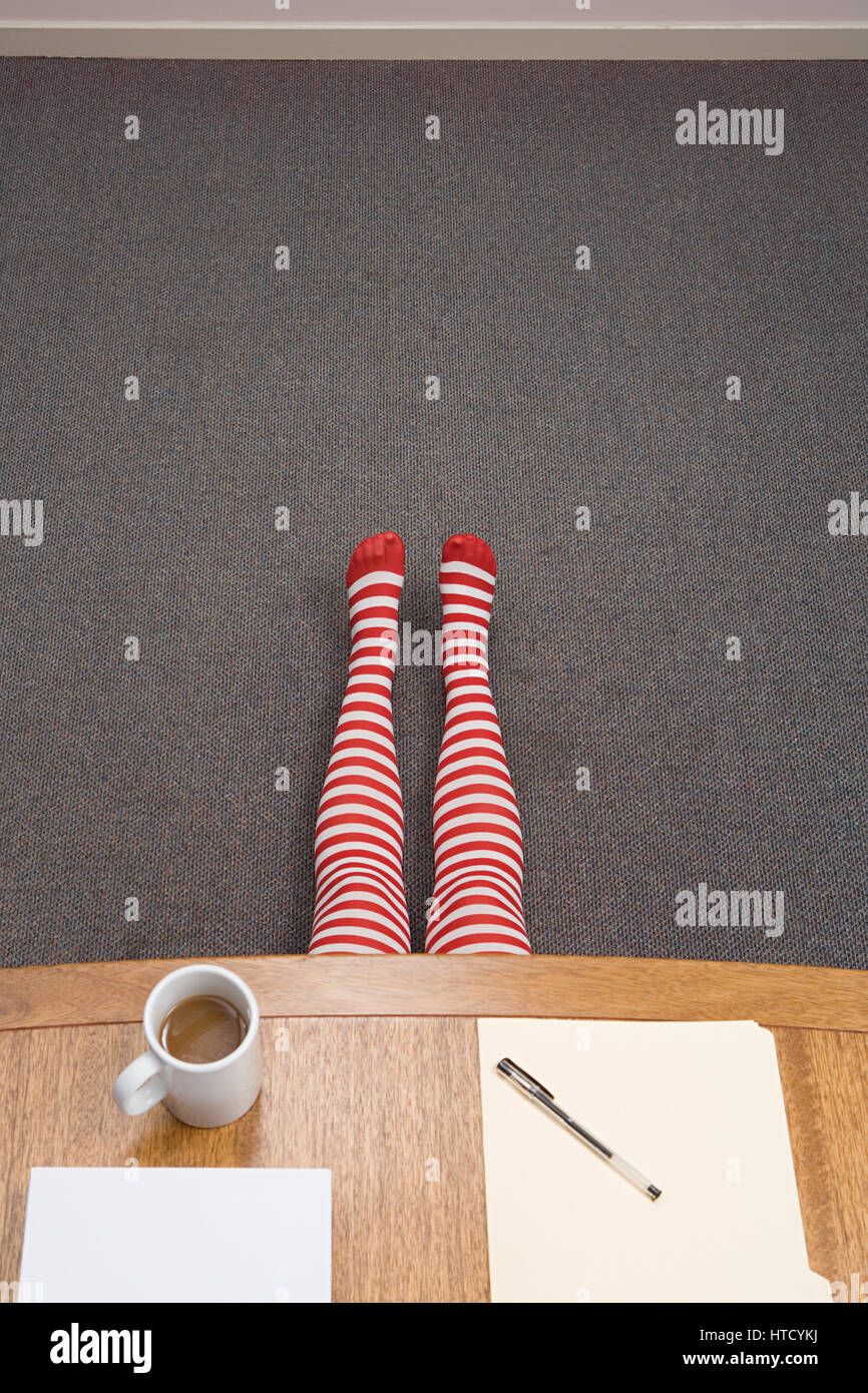 Office worker hiding under desk Stock Photo