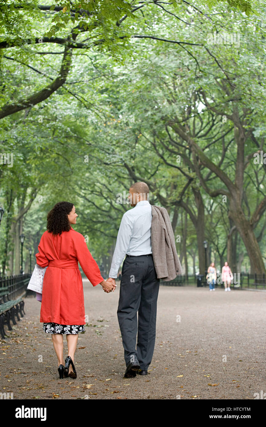 Couple holding hands in the park Stock Photo - Alamy