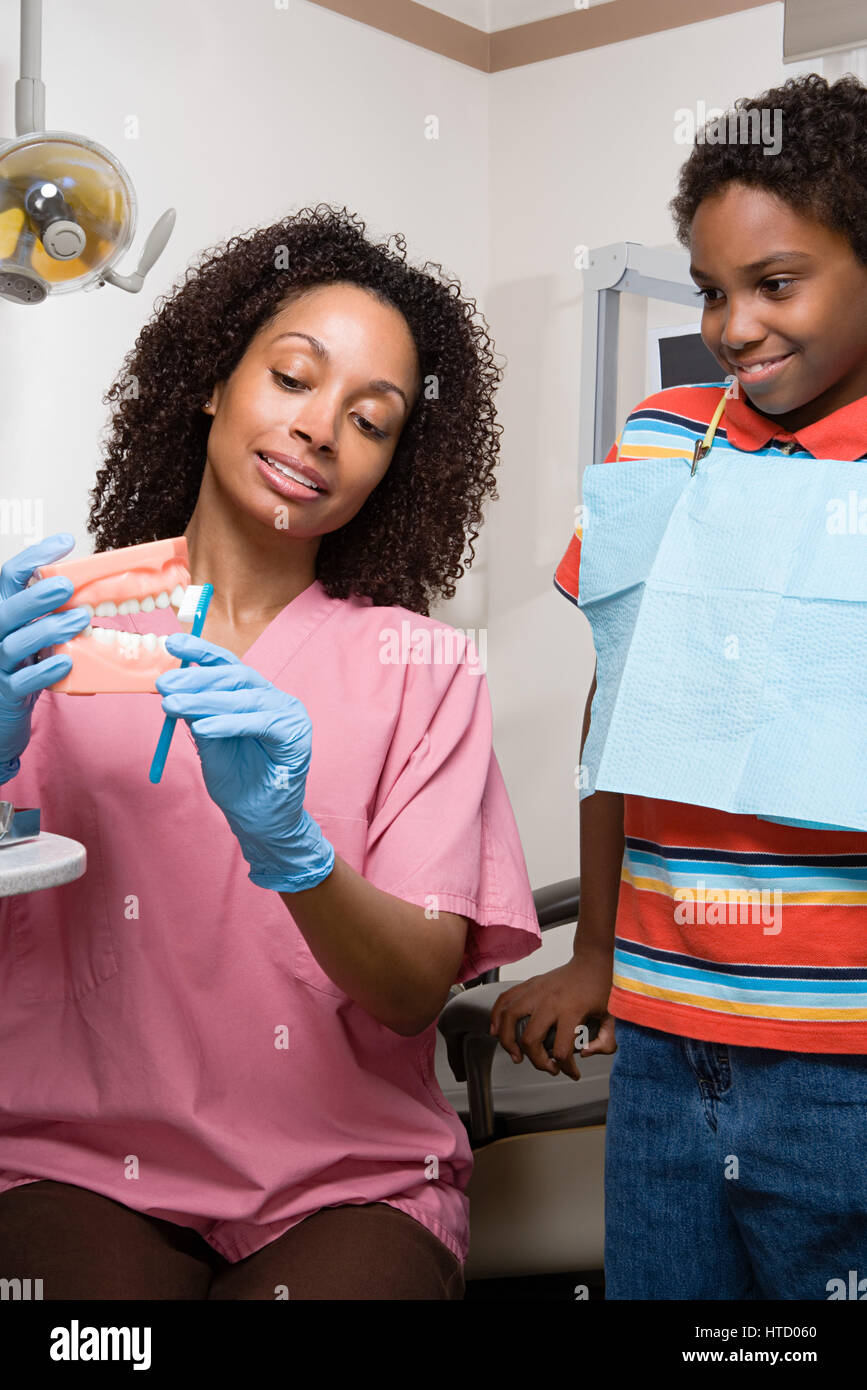 Dental nurse showing boy how to clean teeth properly Stock Photo Alamy