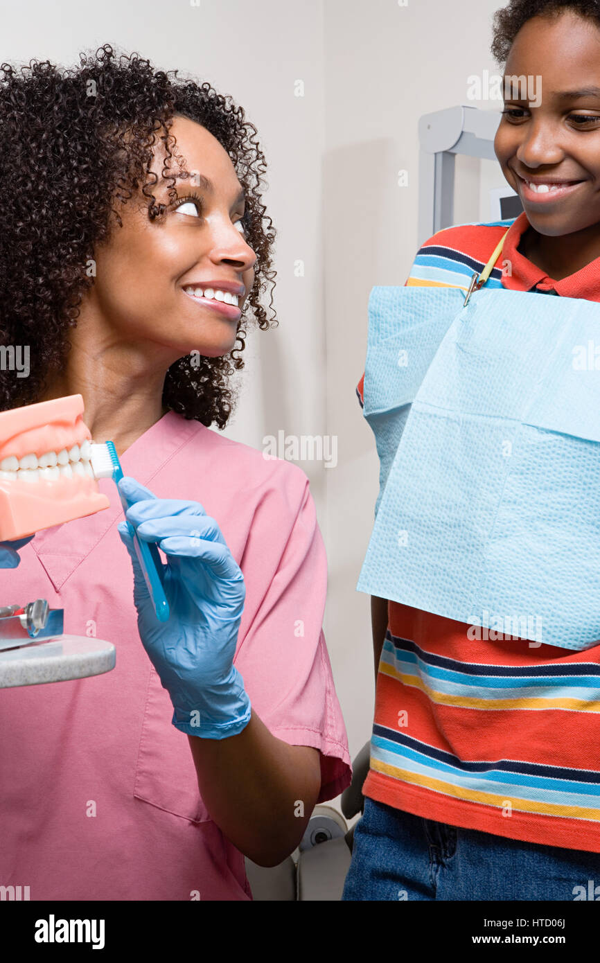 Dental nurse showing boy how to clean teeth properly Stock Photo Alamy
