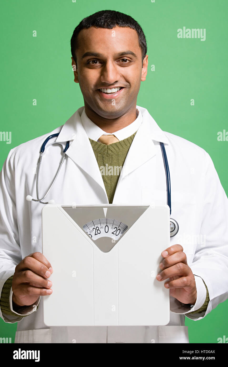 Doctor holding bathroom scales Stock Photo Alamy