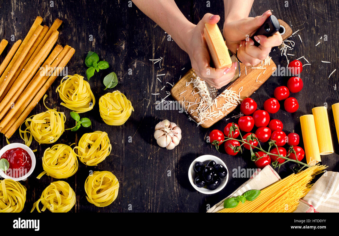 Woman hands preparing pasta on wooden table. Top view Stock Photo - Alamy