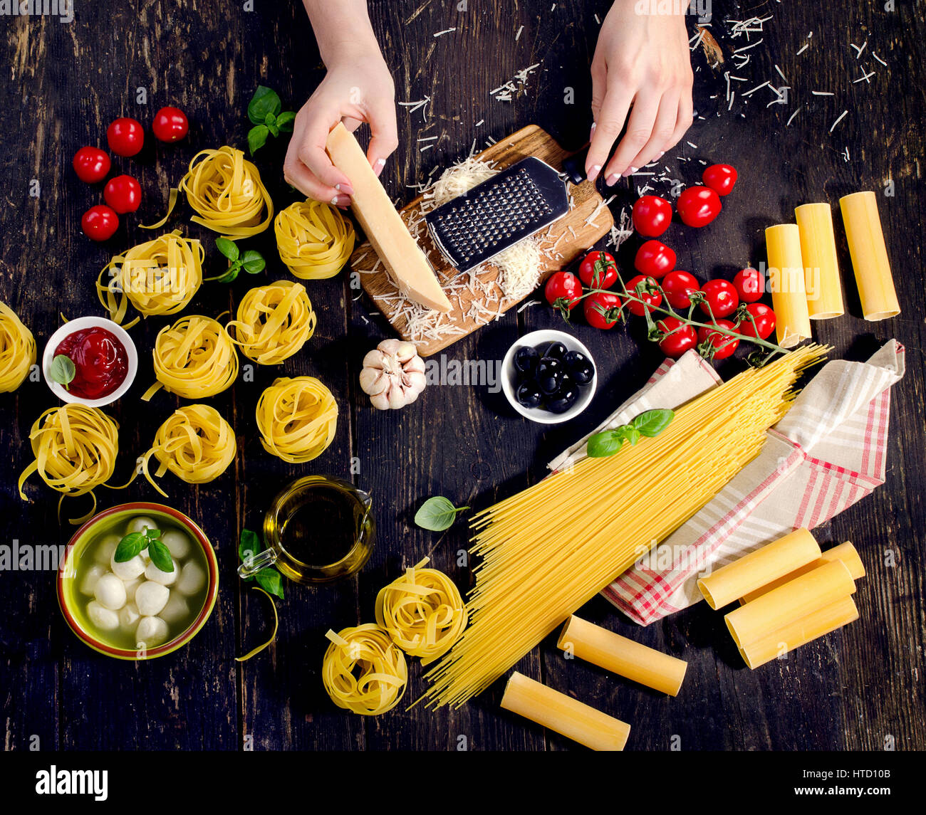 Woman hands preparing italian pasta on a rustic wooden table. Top view ...
