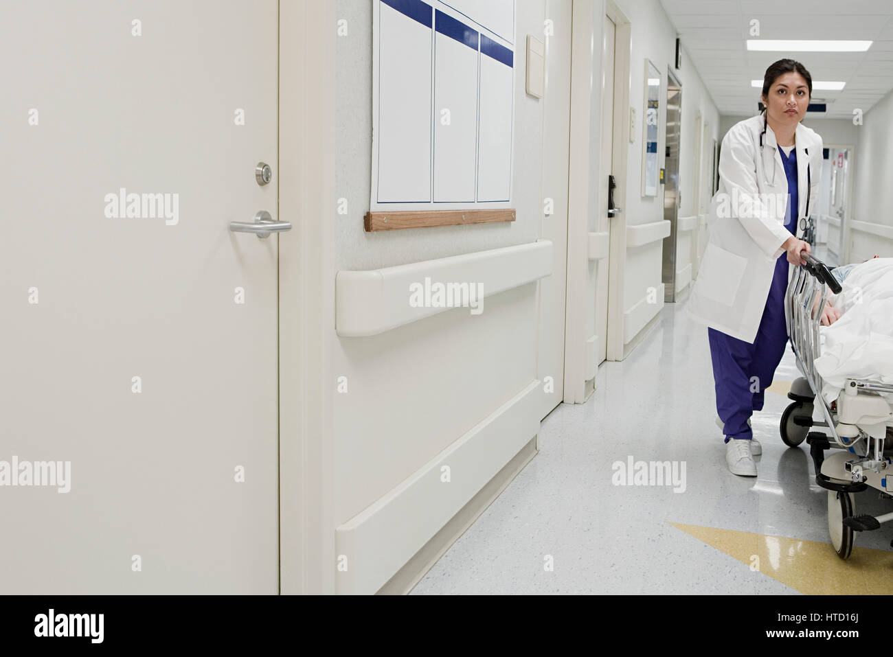 Doctor taking patient down corridor Stock Photo