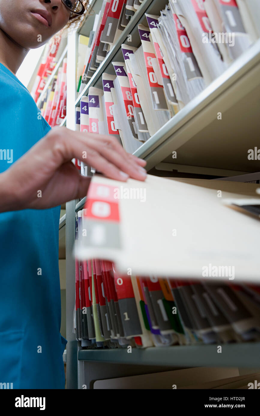 Woman with file in hospital archives Stock Photo