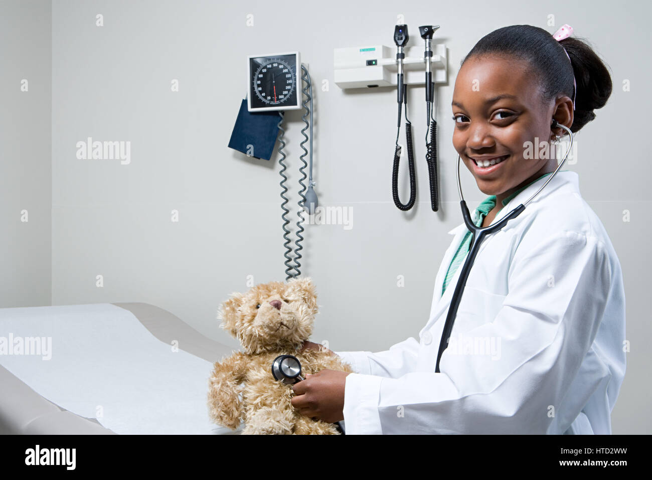 Girl doctor using stethoscope on teddy bear Stock Photo - Alamy