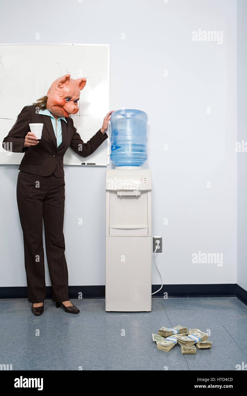 Businesswoman in pig mask looking at money Stock Photo