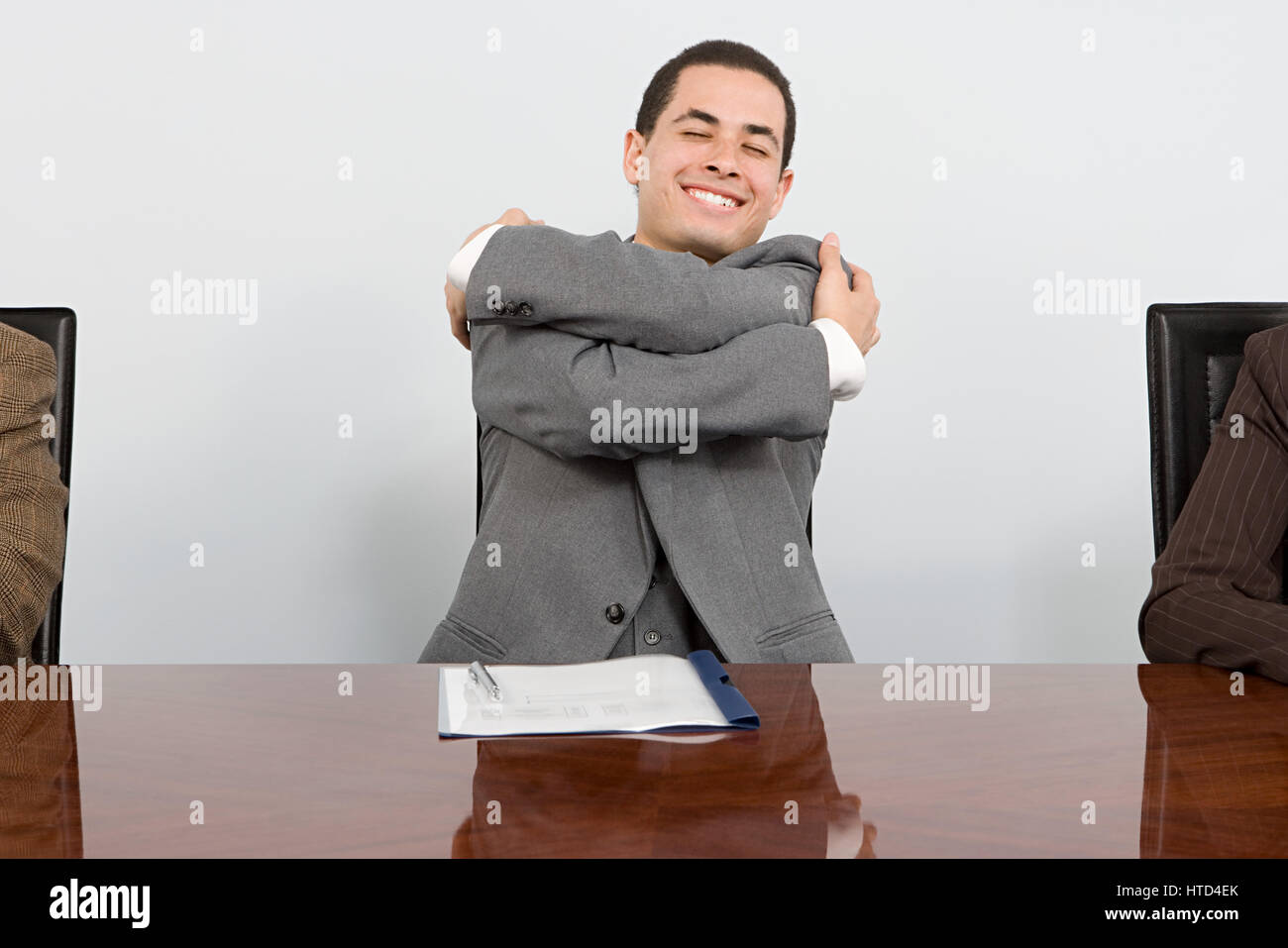 Businessman hugging himself Stock Photo - Alamy