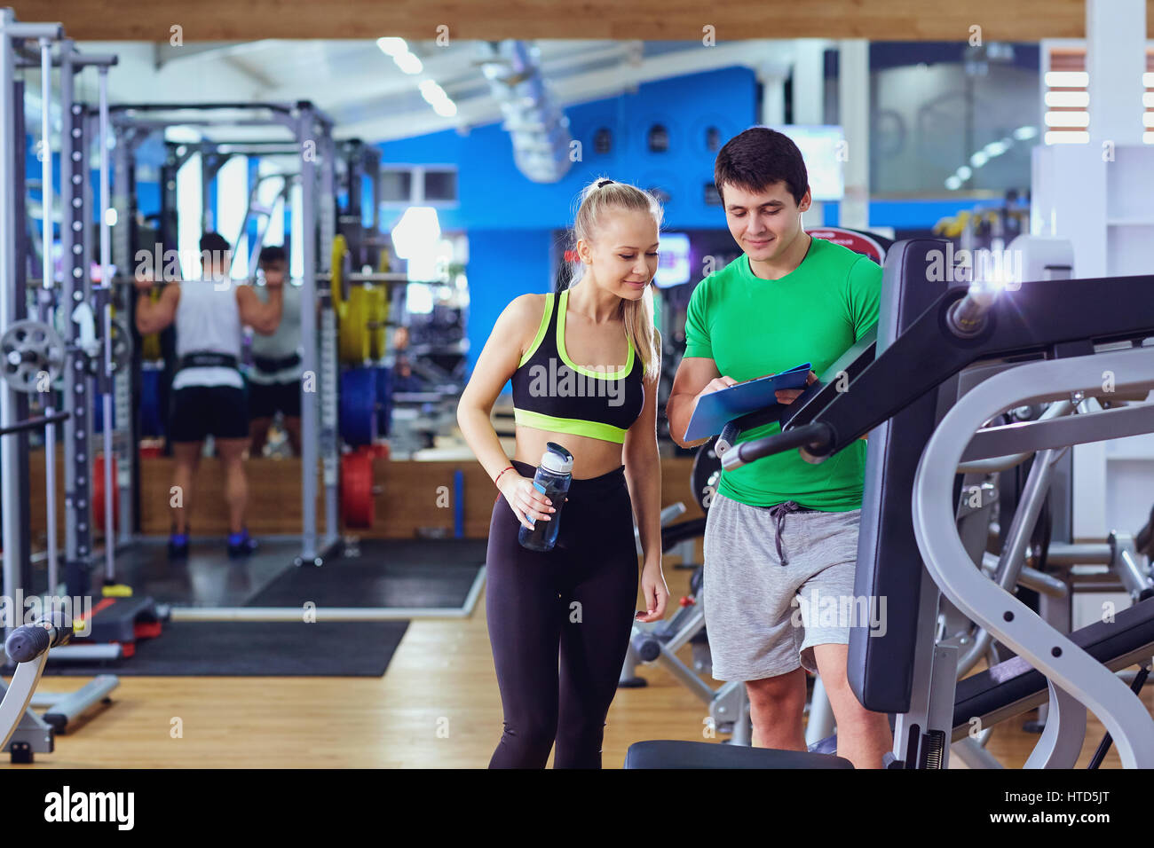 Sports girl blonde with trainer in gym Stock Photo - Alamy