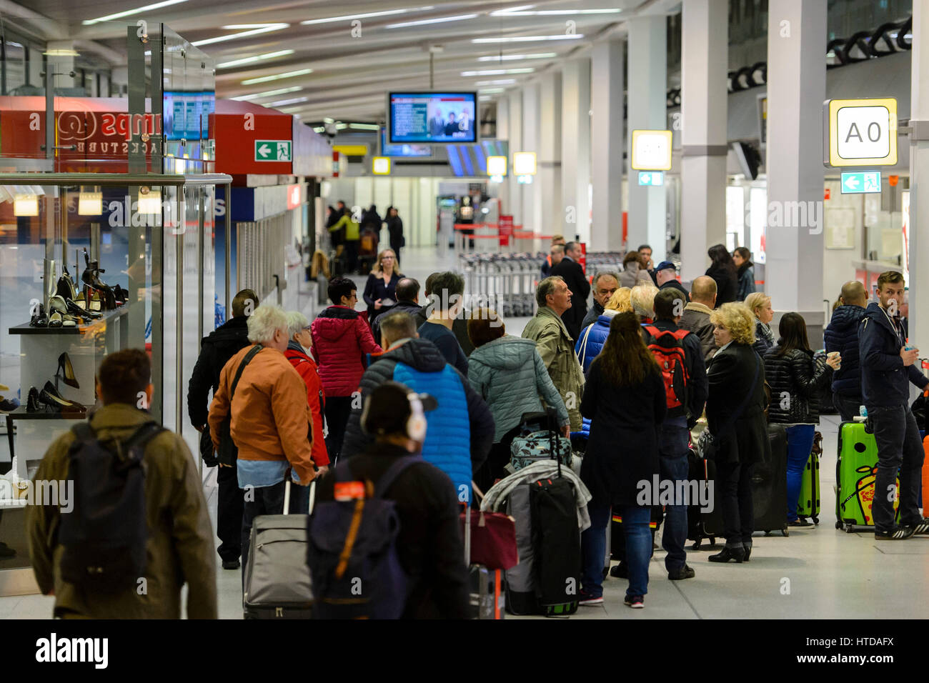 Travellers with their luggage seen in front of an unmanned check-in counter in the terminal building at Tegel Airport in Berlin, Germany, 10 March 2017. German trade union Verdi had called on some 2,000 ground staff to join the strike. The strike began on 10 March 2017 at 03:00 GMT and is to end on 11 March 2017 at 04:00 GMT. The main reason for the strike is the ongoing labour dispute between Verdi and the Forum of Ground Transport Service Providers in which the companies operating at the airports are organized. The trade union is demanding a pay rise for ground staff. Photo: Gregor Fischer/d Stock Photo