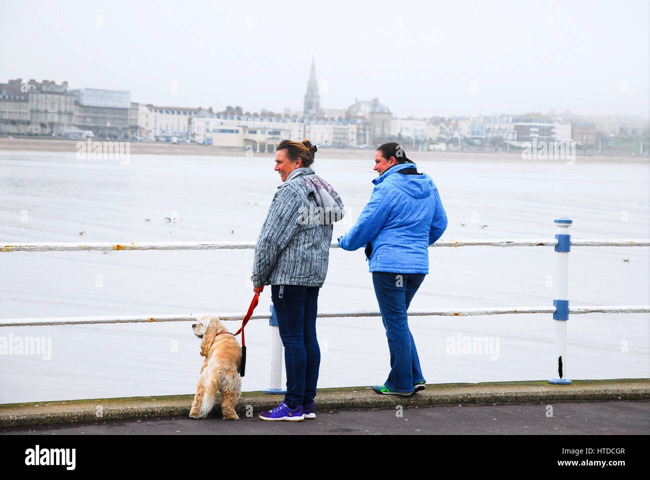 Weymouth & Portland, Dorset, 2017, Rising temperatures brings sea mist, as people enjoy the beach and the harbour on an overcast day Stock Photo