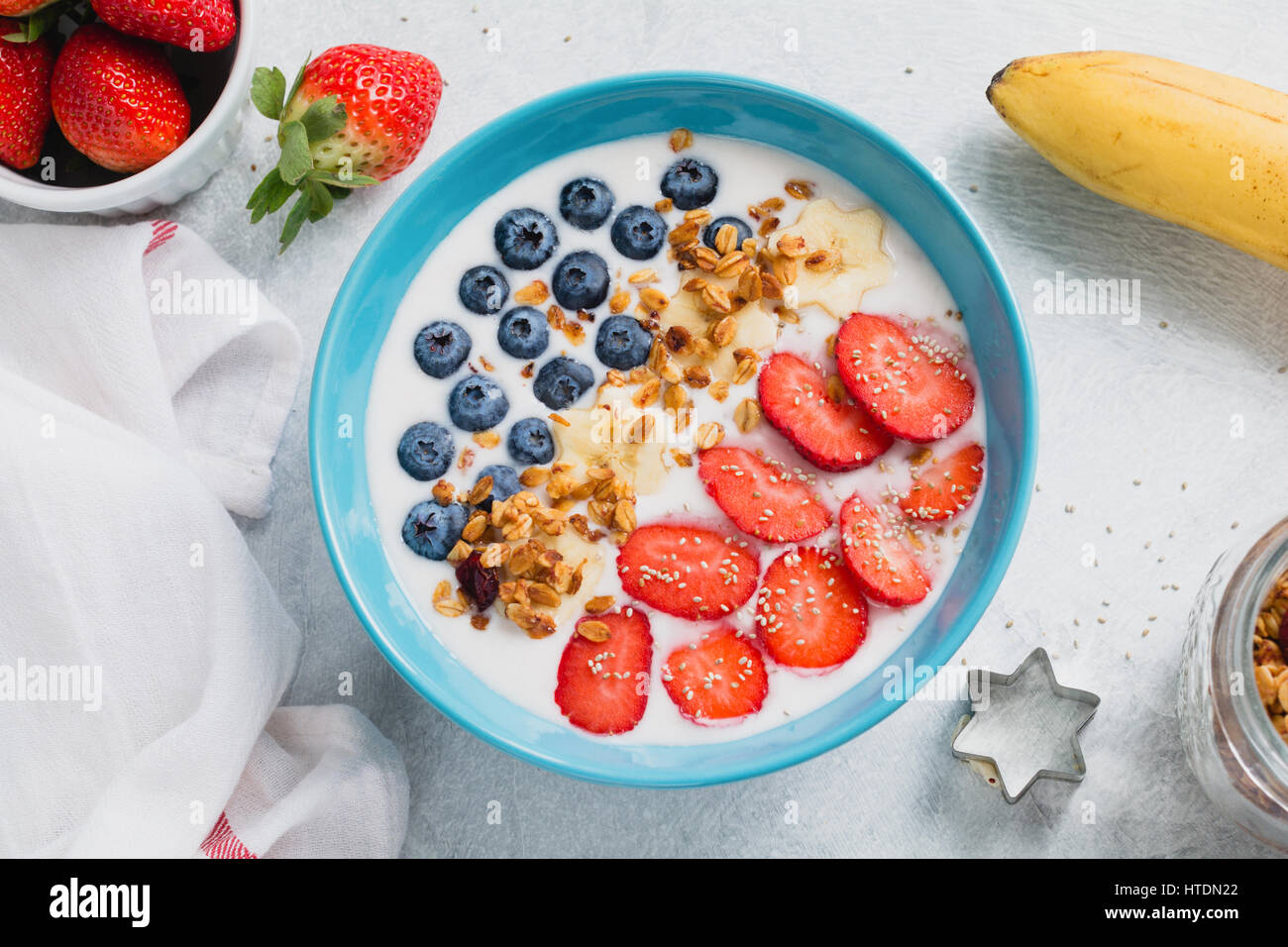 Yogurt bowl with fresh strawberries, blueberries and granola. Table top view Stock Photo