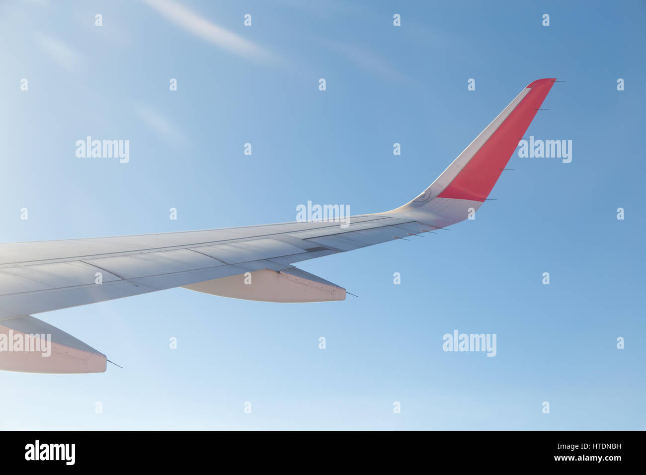 Wing of an airplane flying above the blue sky and clouds Stock Photo ...
