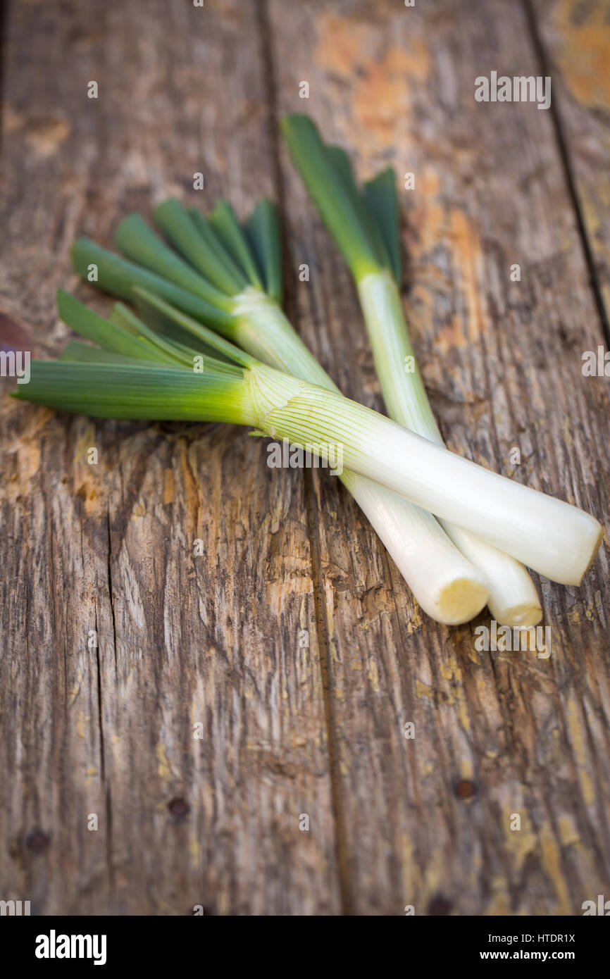 Fresh raw spring onions on a wooden board Stock Photo - Alamy