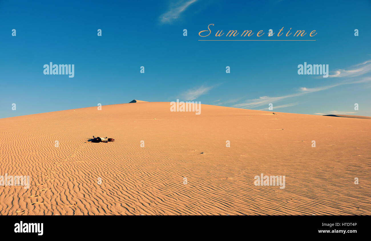 Summertime vacation trip of young people at Vietnam sand hill, woman relaxing on yellow sandy under sky, wonderful scene with girl enjoy summer ion ca Stock Photo