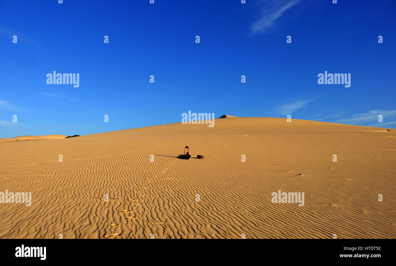 Summertime vacation trip of young people at Vietnam sand hill, woman relaxing on yellow sandy under sky, wonderful scene with girl enjoy summer ion ca Stock Photo