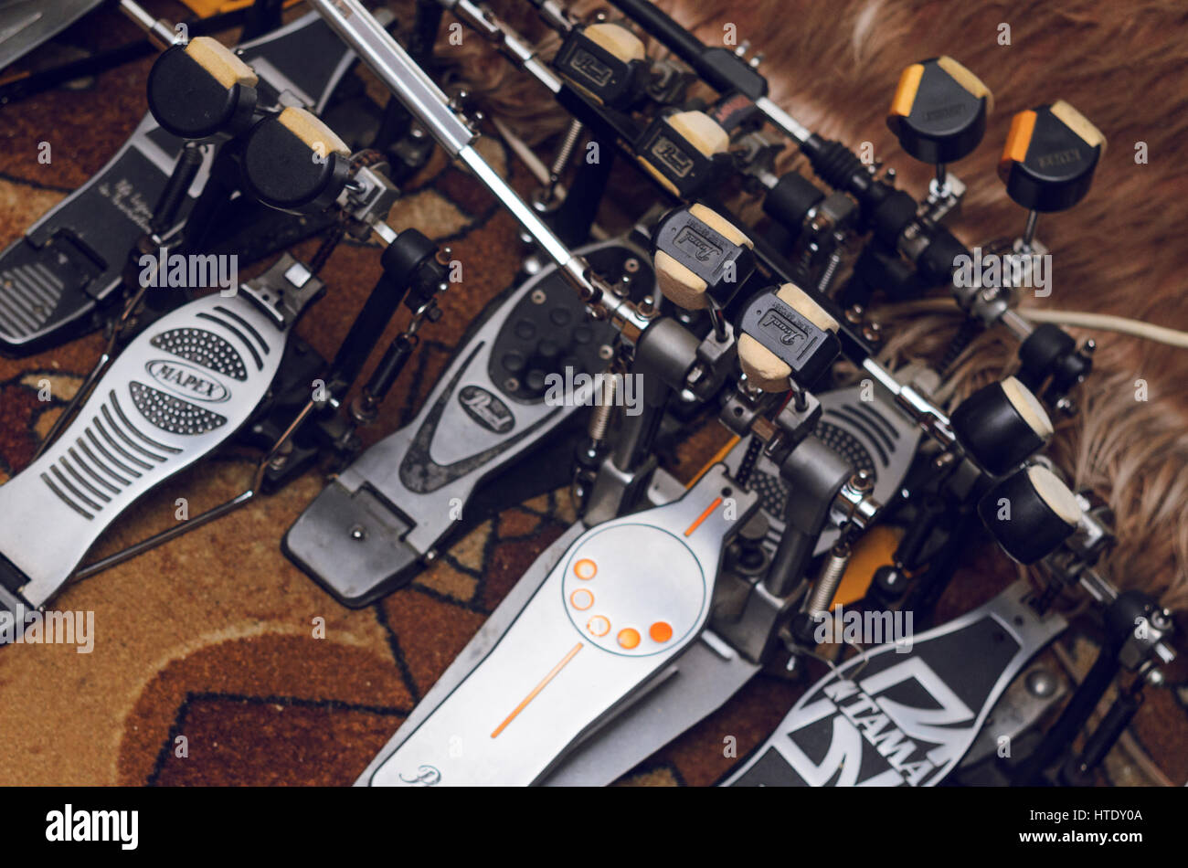Rehearsal studio, Minsk, Belarus. A set of accessories for playing on the drum set. Warehousing of musical equipment. Twin pedals for drums from diffe Stock Photo