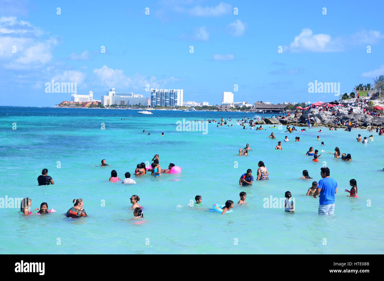 Local people swim in the sea on a public beach in Cancun, Mexico Stock