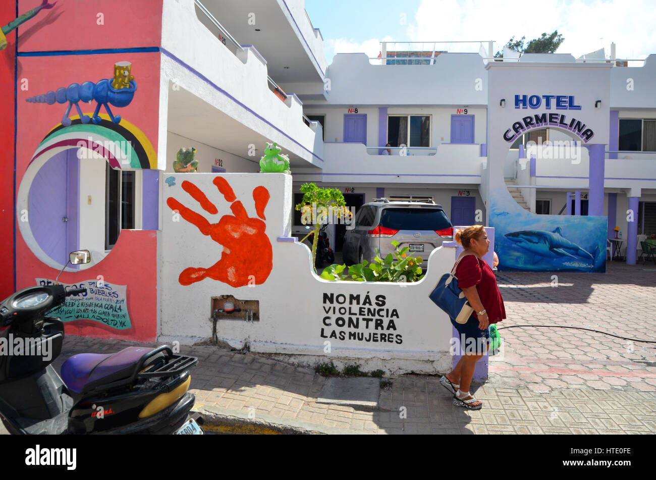 a woman walks in front of a slogan against violence against women isla mujeres mexico Stock Photo