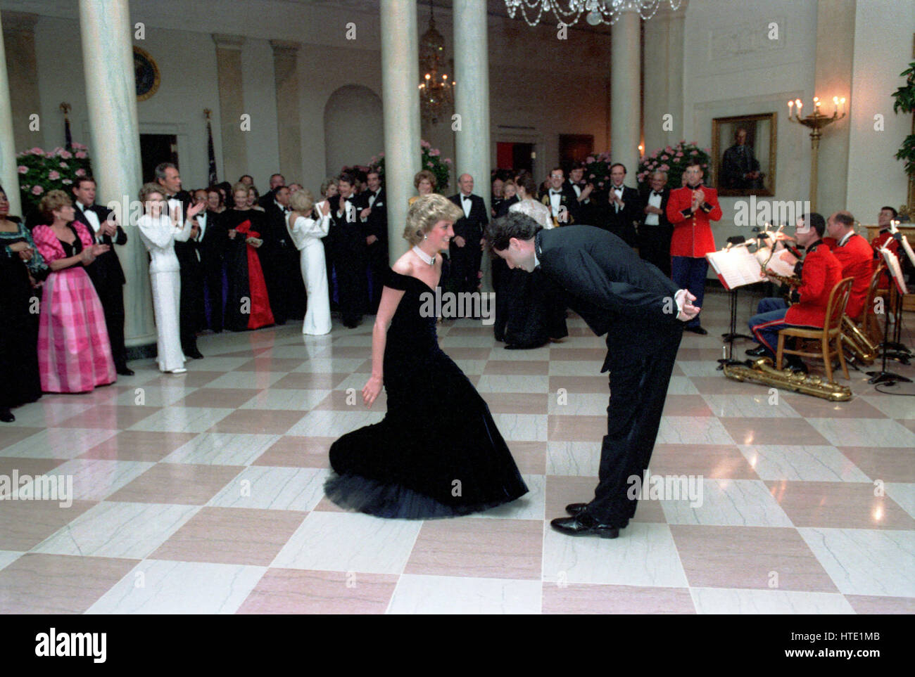 Princess Diana dances with John Travolta in the Cross Hall of the White House in Washington, D.C at a Dinner for Prince Charles and Princess Diana of the United Kingdom on November 9, 1985 Mandatory Stock Photo
