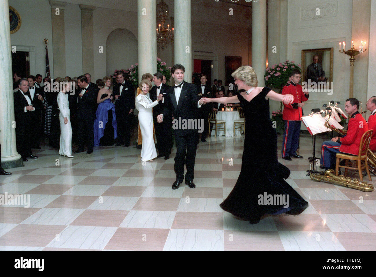 Princess Diana dances with John Travolta in the Cross Hall of the White House in Washington, D.C at a Dinner for Prince Charles and Princess Diana of the United Kingdom on November 9, 1985 Mandatory Stock Photo