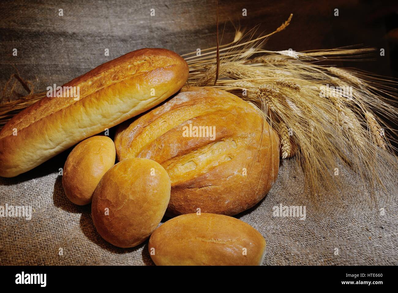 bread, loaf, white bread, wheat ears on a background of burlap ...