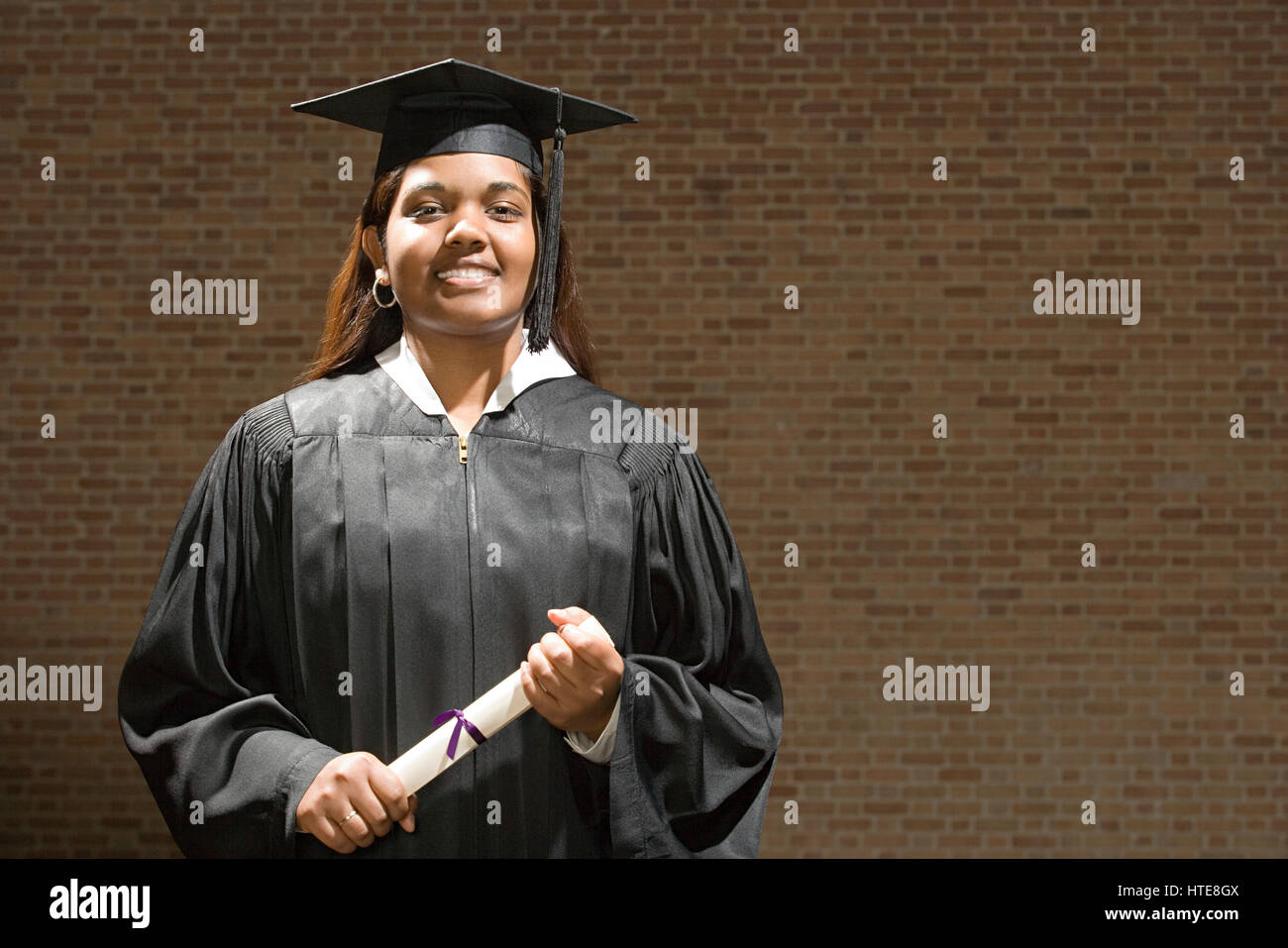 Female graduate holding her diploma Stock Photo - Alamy