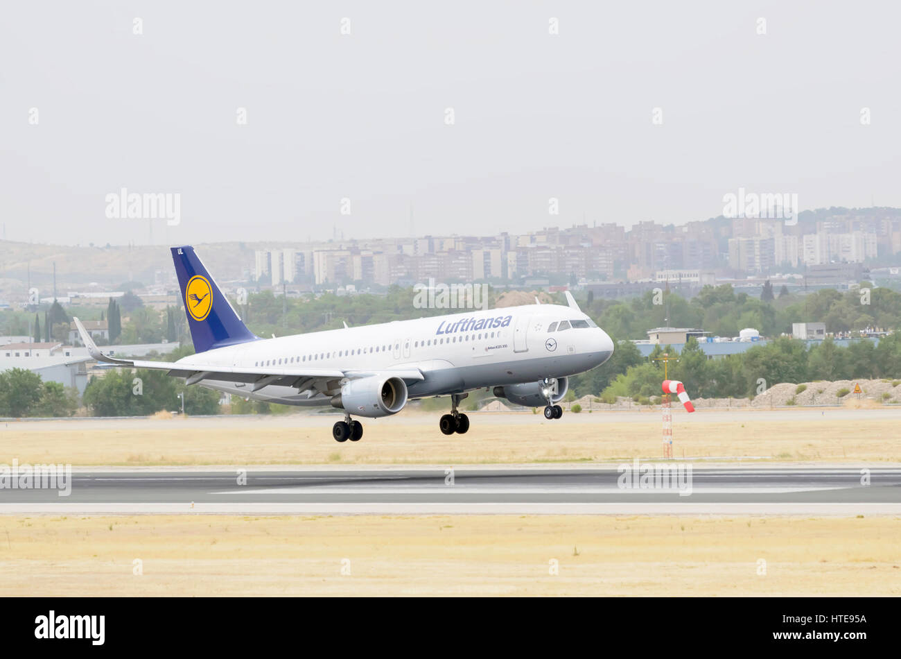 Plane Airbus A320, of Lufthansa airline, is landing on Madrid - Barajas, Adolfo Suarez airport. Cloudy day of summer. Stock Photo