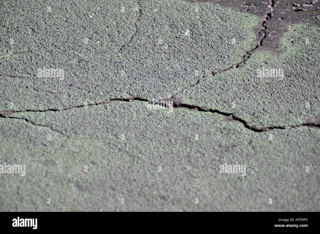 Cracks in tarmac road surface. Stock Photo