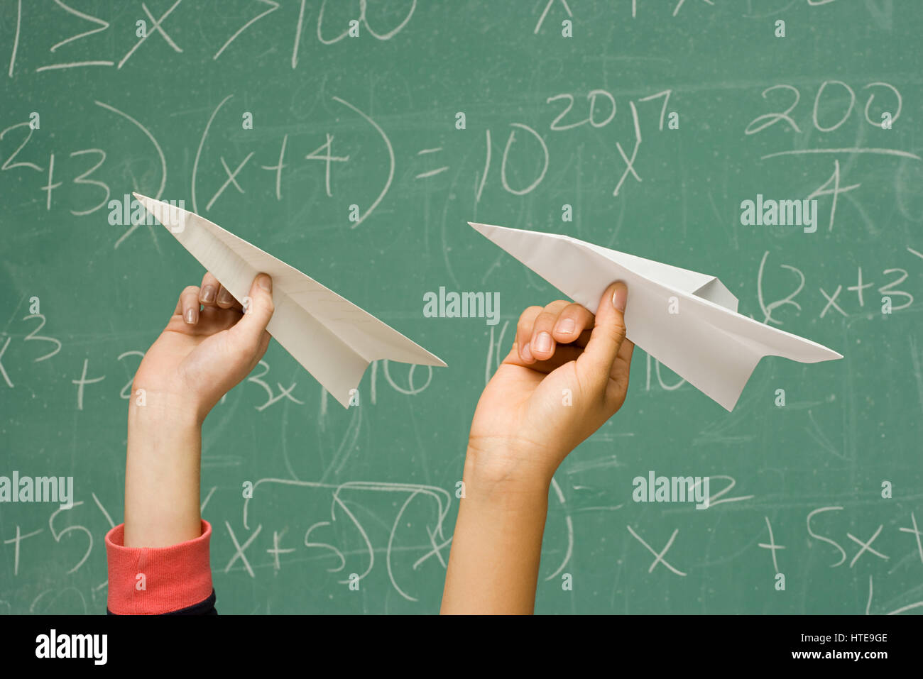 Two students about to throw paper aeroplanes Stock Photo