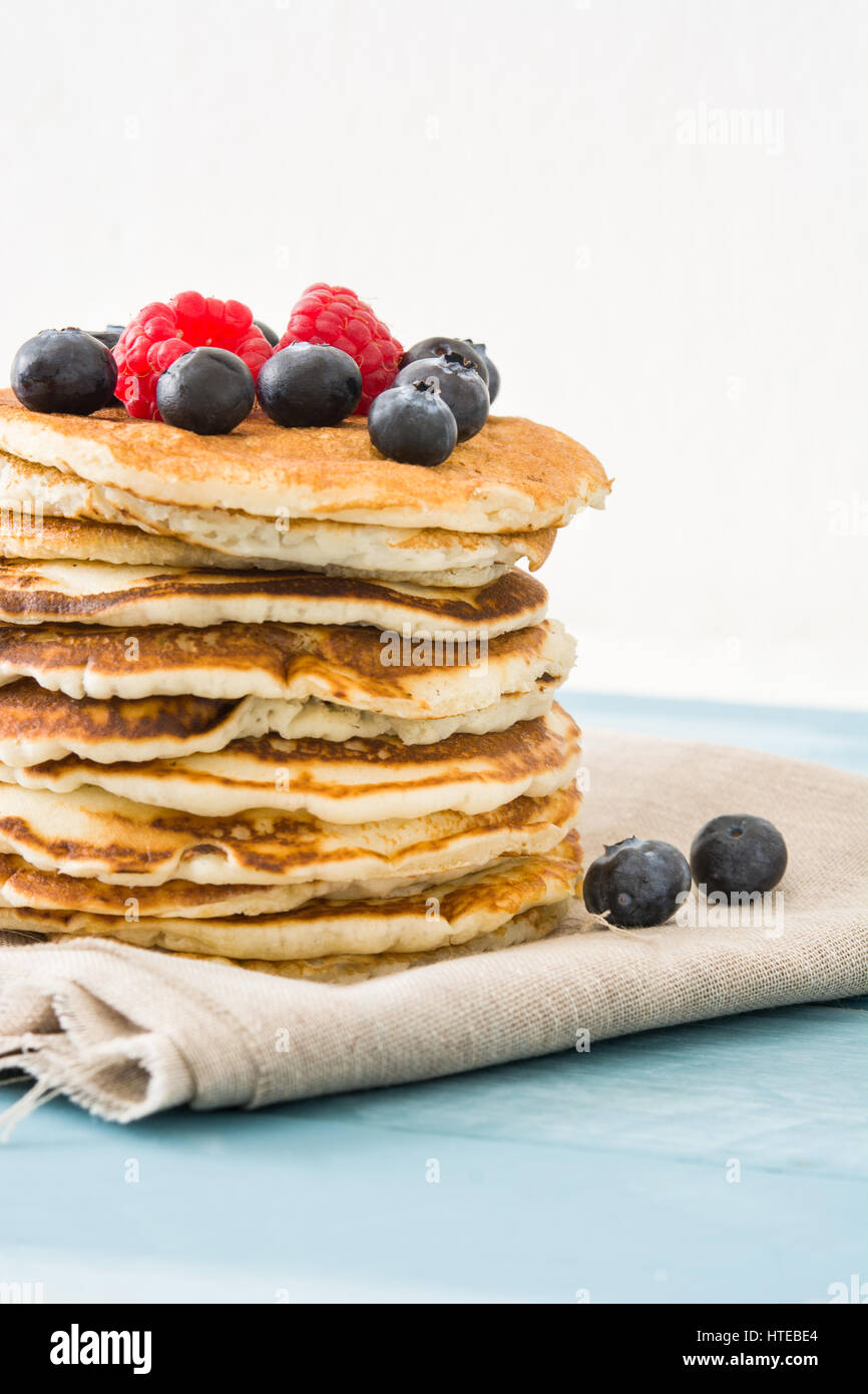 Pancake with blueberries and raspberries on blue wooden table Stock ...