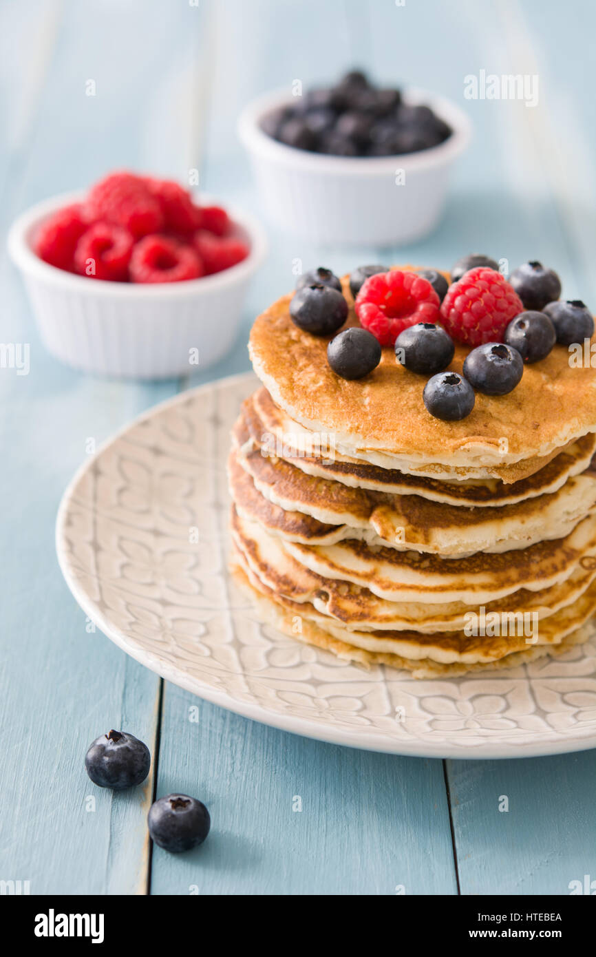 Pancake with blueberries and raspberries on blue wooden table Stock ...