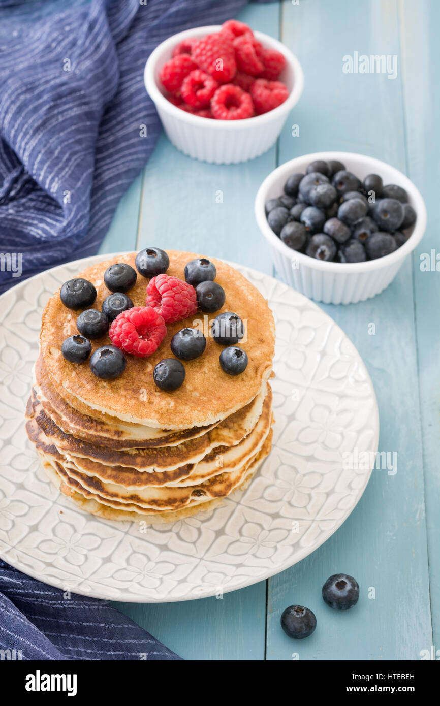 Pancake with blueberries and raspberries on blue wooden table Stock ...