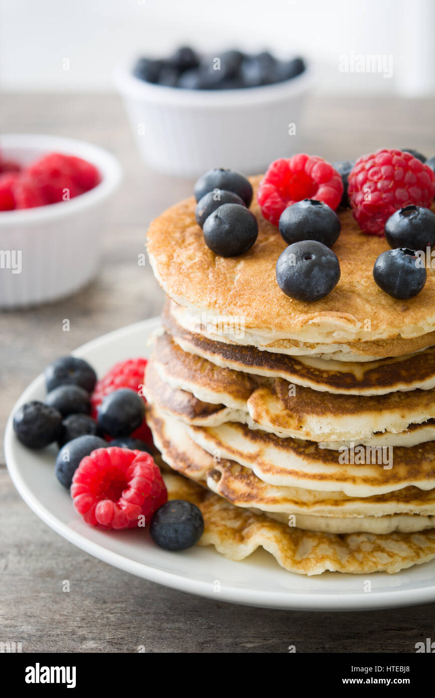 Pancakes with blueberries and raspberries on rustic wood Stock Photo ...