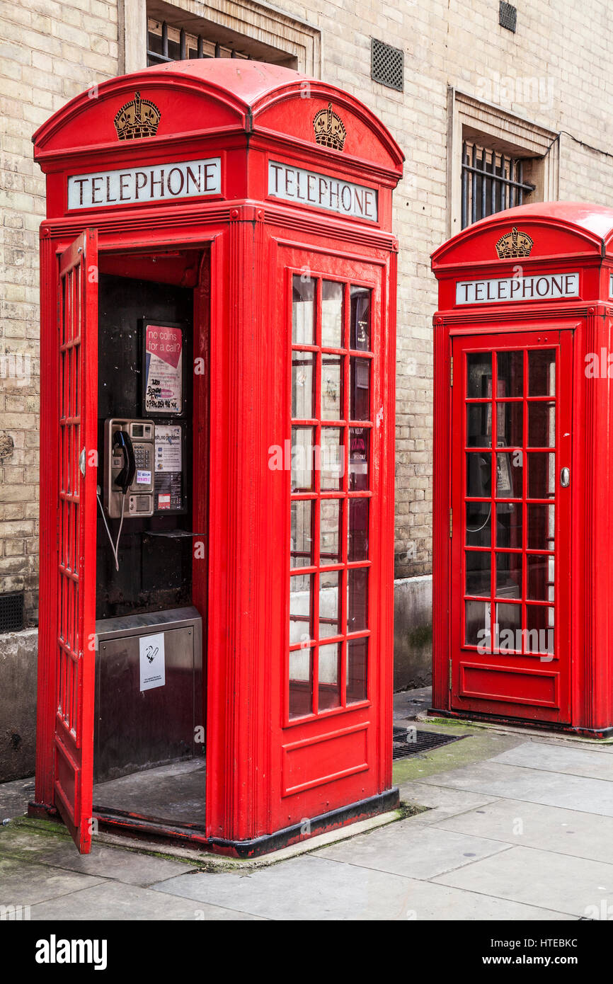 Two red telephone boxes in London, one with open door. Stock Photo