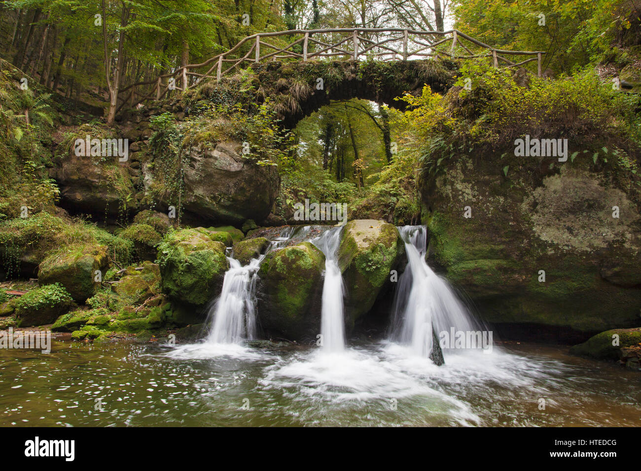Stone Bridge over the Schiessentumpel Waterfall, part of the Mullerthal Trail, Luxembourg. Stock Photo