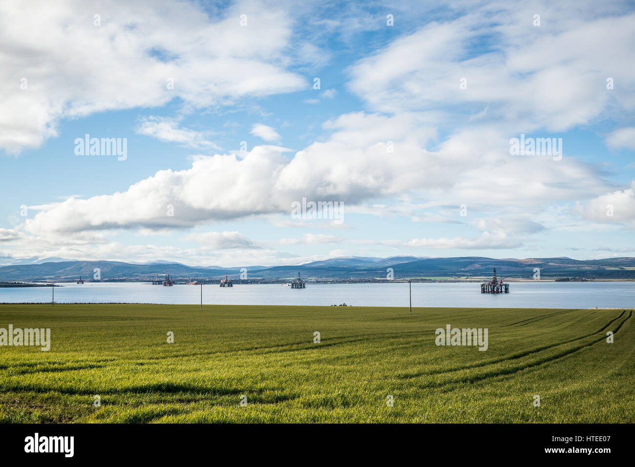 North Sea oil and gas rigs lined up in the sheltered waters of the Cromarty Firth for maintenance and refurbishment. Stock Photo
