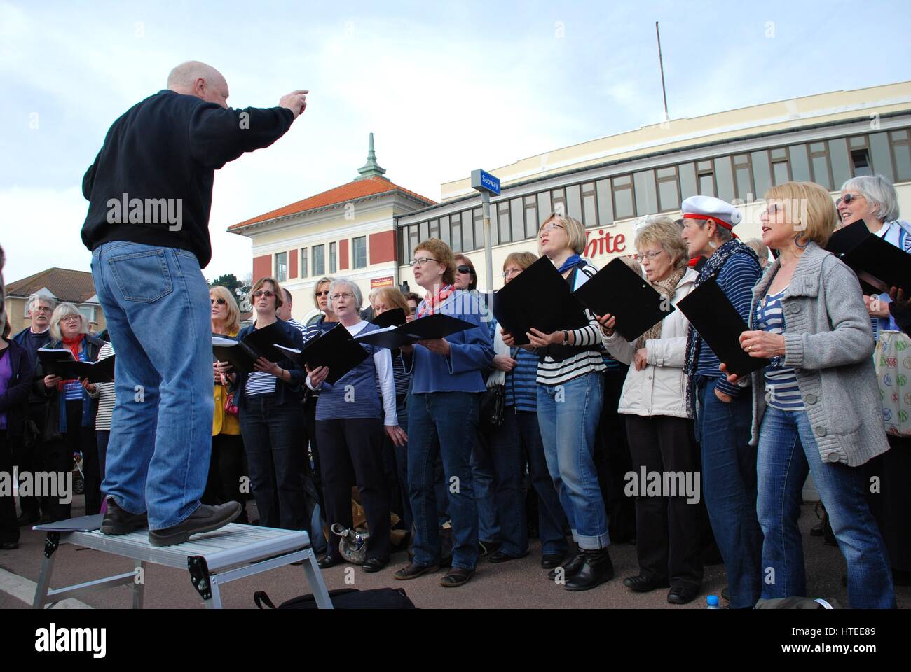 The Soundwaves community choir perform on the seafront at Hastings, England at a fund raising event for the Victorian pier. Stock Photo