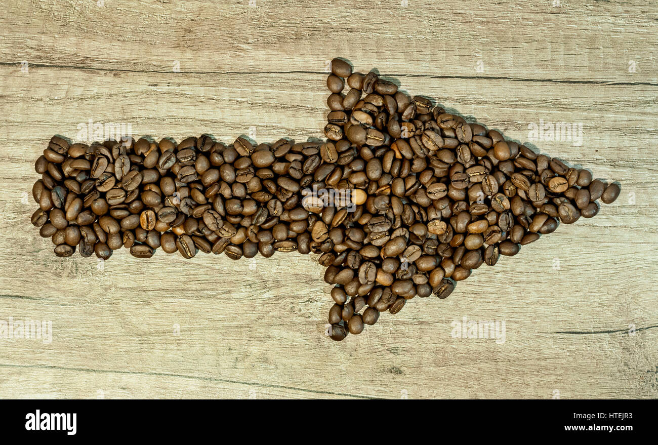 Coffee beans in the form of arrows on wooden background Stock Photo