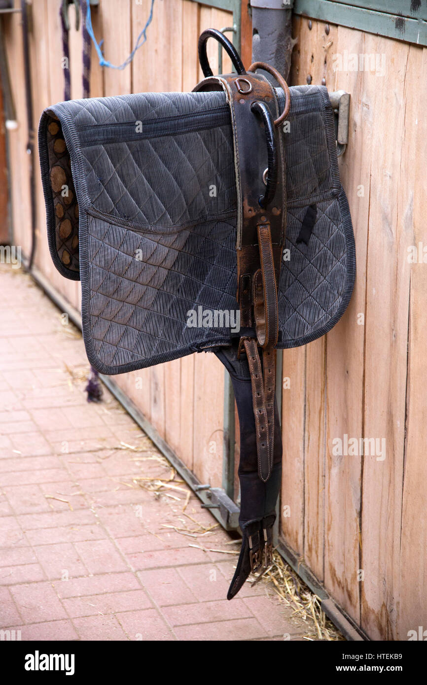 Sporty saddle blanket hanging in a rural barn Stock Photo