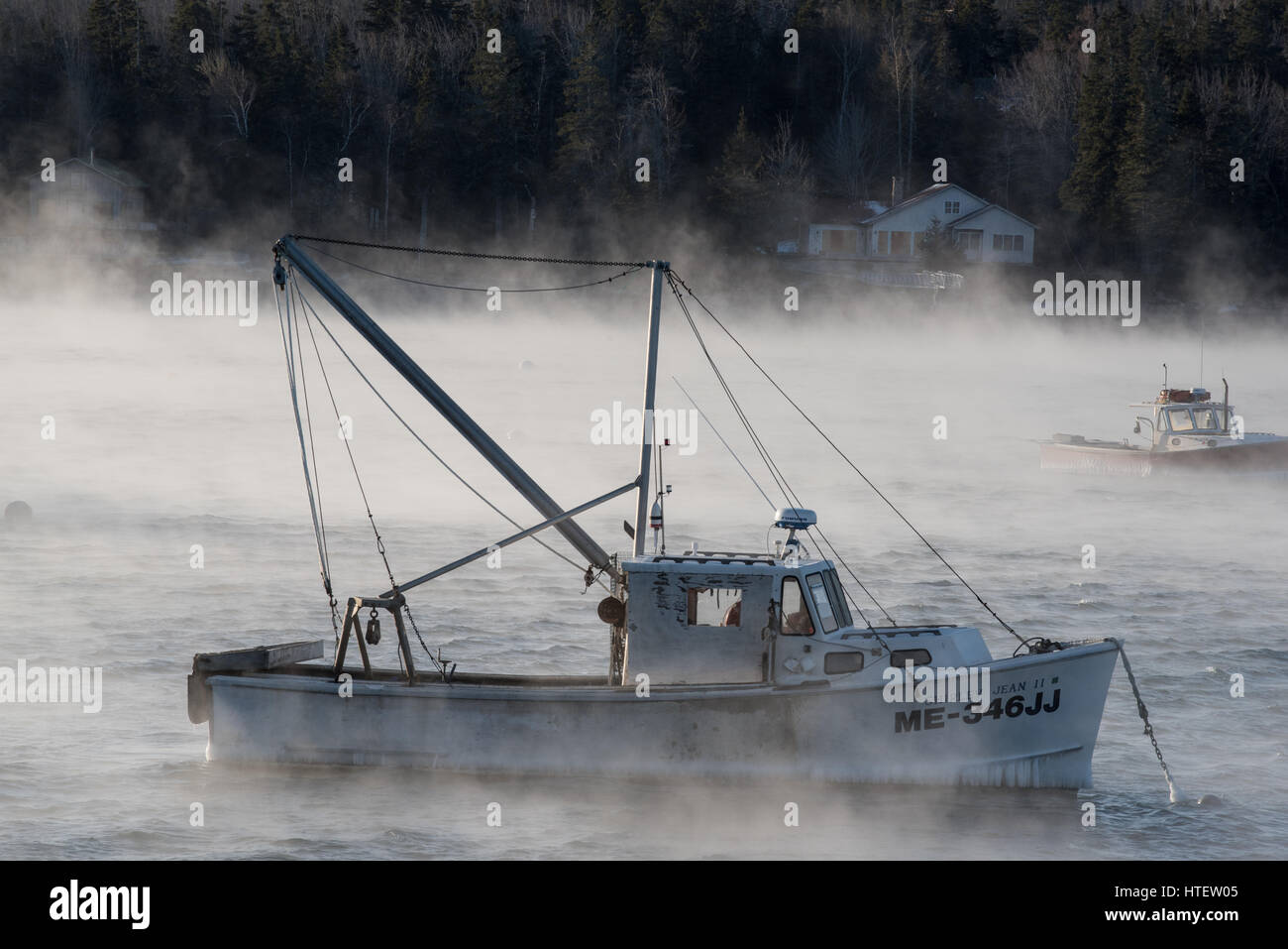 Sea smoke rises from the surface and surrounds lobster boats with temperature of minus 11 degrees F. Southwest Harbor, Acadia National Park, Maine. Stock Photo