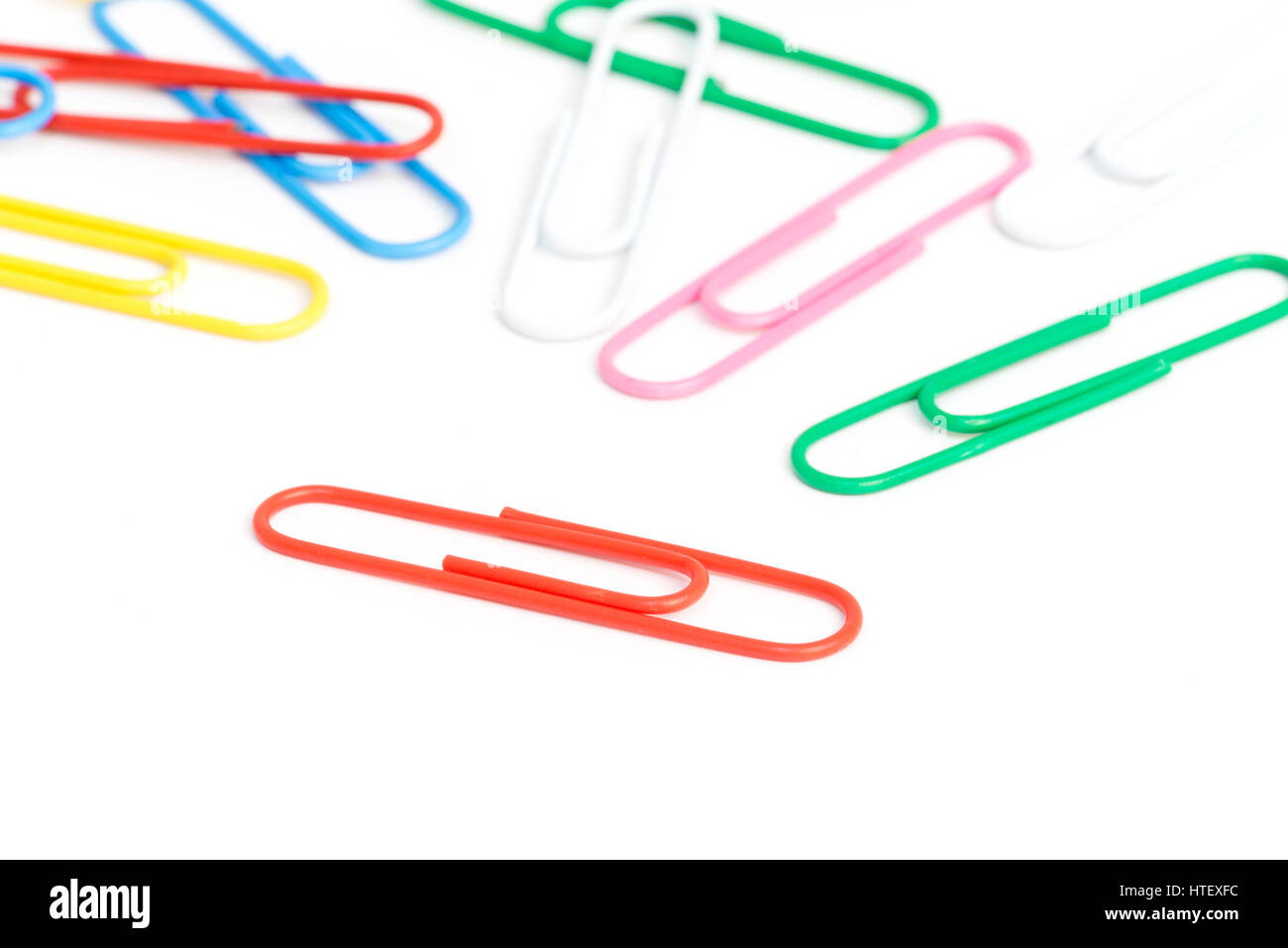 Paper clips.  Random jumble of assorted plastic covered paper clips on white background Stock Photo