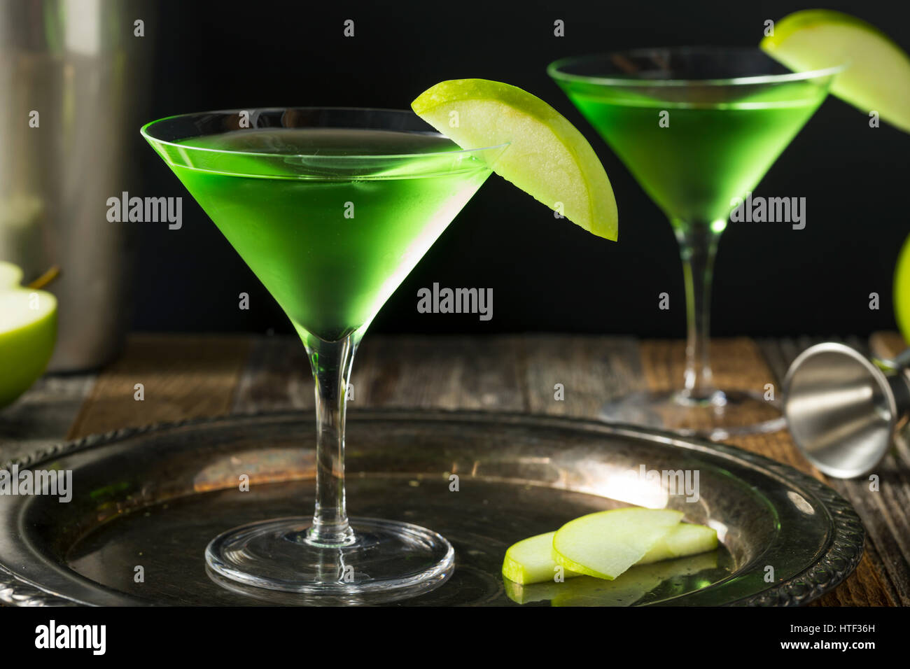 Homemade Green Alcoholic Appletini Cocktail with Apple Garnish Stock