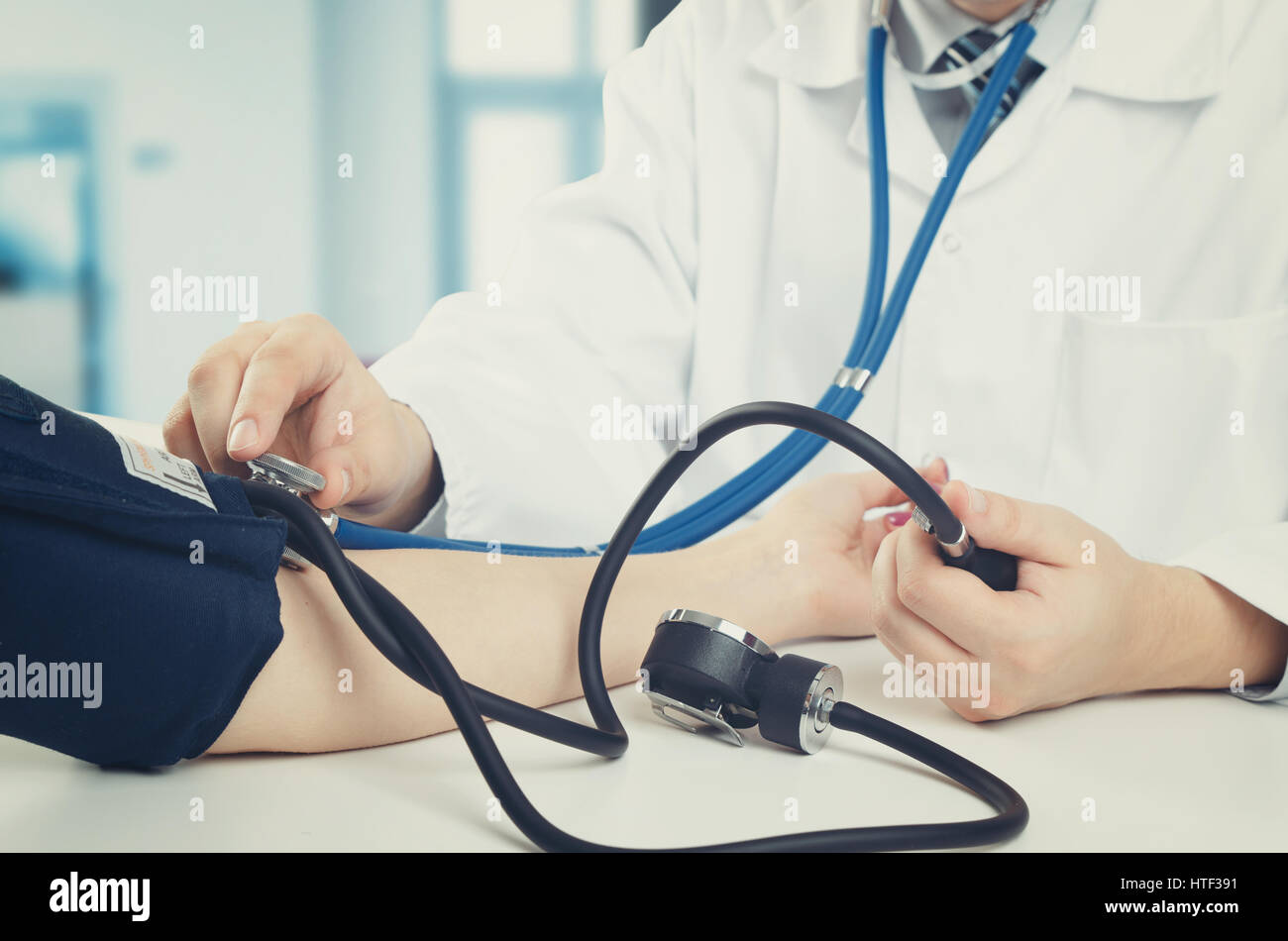 Doctor measures the pressure of the patient. doctor patient blood pressure clinic sphygmomanometer medical worker concept Stock Photo